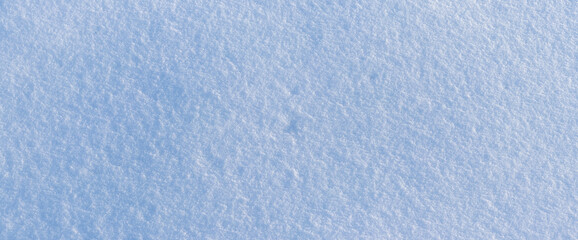 Snowy background, snowy surface with a clearly expressed texture of snow in the morning sun
