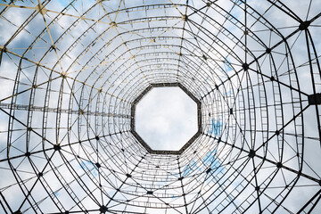 Bottom-up view of a steel structure against the sky. The concept of a radio telescope and astronomy or an abstract industrial pattern