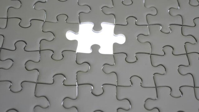 Hand holding jigsaw puzzle last missing piece lighting. 
Concept last piece of jigsaw puzzle for problem and 
completion.