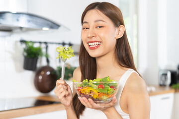 Diet, Dieting asian young woman or girl hand using fork at lettuce, green oak on mixed vegetables in salad bowl, eat food is low fat good health. Nutritionist female, Weight loss for healthy person.