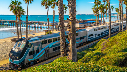 Metro commuter train entering San Clemente Pier Beach Station in Southern California - obrazy, fototapety, plakaty