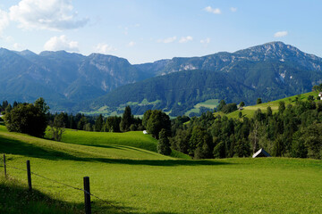 Fototapeta na wymiar a hiking trail overlooking the picturesque alpine landscape with a vast green alpine valley in the Austrian Alps of the Schladming-Dachstein region (Schladming, Austria)