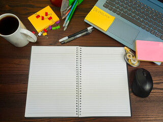 Flat lay, a mockup of a notebook. A workspace with white notebooks, laptops, office supplies,and coffee cups in the office background of a wooden desk from top view.
