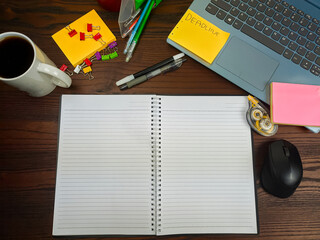 Flat lay, a mockup of a notebook. A workspace with white notebooks, laptops, office supplies,and coffee cups in the office background of a wooden desk from top view.