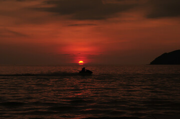 jet skis are gliding in the sea at dusk