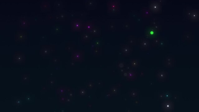 Multicolored slow-falling particles. Particles from bokeh on a dark blue background.