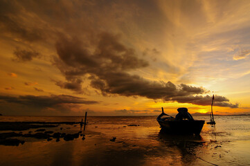 a fishing boat on the beach at dusk
