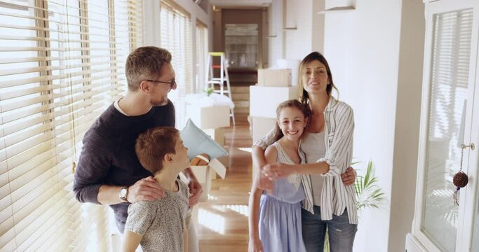 House, property and family in their new home, proud and happy while moving in, hug and embrace. Real estate, happy family and dream home with kids, parents and boxes on move day, hugging for portrait