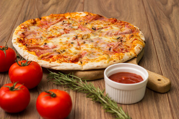 Capricciosa whole pizza on wooden table
