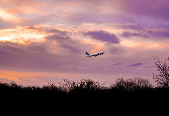Fototapeta na wymiar Sunrise silhouetting a plane 