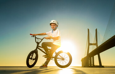 Teenage BMX rider is prepearing to tricks in skatepark.