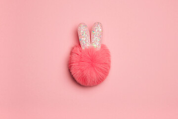 Pink fluffy rabbit on a pink background. Fluffy pompom with cute ears. Christmas concept.