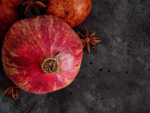 pomegranate and spices on wooden background