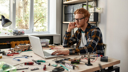 Focused male IT technician use and watch laptop