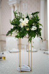 Wedding centerpieces, with metal vase and green fresh flowers arrangements.