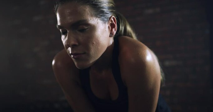 Woman, tired or breathing in gym workout, training or exercise in heart health, cardio wellness or healthcare. Exhausted, fatigue or sweating fitness athlete, personal trainer or coach in dark center