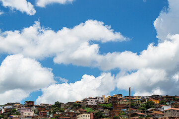Beautiful landscape with blue sky many clouds and houses at the top of the hill.