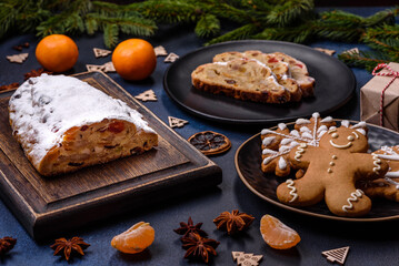 Delicious festive New Year's pie with candied fruits, marzipan and nuts on a dark concrete background