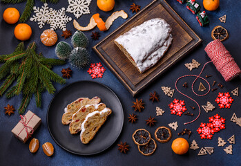 Obraz na płótnie Canvas Delicious festive New Year's pie with candied fruits, marzipan and nuts on a dark concrete background