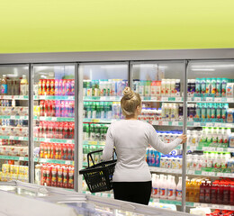 Woman choosing frozen food from a supermarket freezer