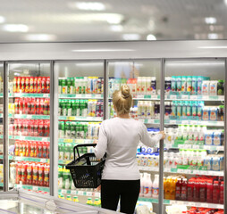 Woman choosing frozen food from a supermarket freezer