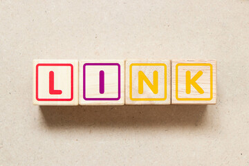 Color letter block in word link on wood background