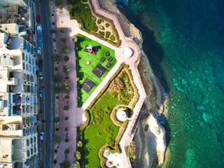 aerial drone top view of coastal residential area, a children's playground and garden park along...