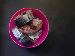 Fish meat in purple plastic bowl