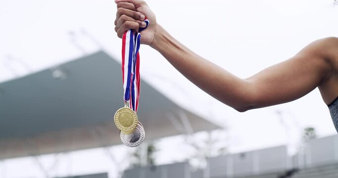 Winner, sports and girl hands with medal prize at champion running competition stadium. Gold, silver and athlete achievement of black woman runner with success, victory and win at event.