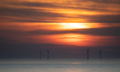 striking sunset and windmills in sea