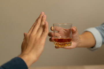 Alcoholism, sad depressed asian young man, male hand holding glass, refuse alcoholic beverage, drink whiskey at night. Treatment of alcohol addiction, having suffered abuse problem alcoholism concept. - obrazy, fototapety, plakaty
