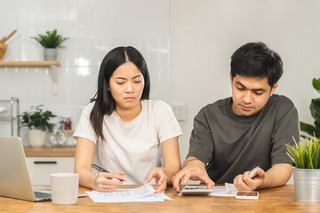 Stressed couple family, wife and husband confused, hand use calculator calculate expense from invoice, have no money to pay. Mortgage, loan causing debt, bankruptcy. Debt problems, Financial people.