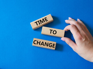 Time to change symbol. Concept word Time to change on wooden blocks. Businessman hand. Beautiful blue background. Business and Time to change concept. Copy space