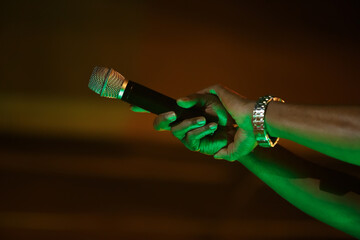 Rap singer with mic in hand. Black rapper performing on concert with wireless microphone - obrazy, fototapety, plakaty