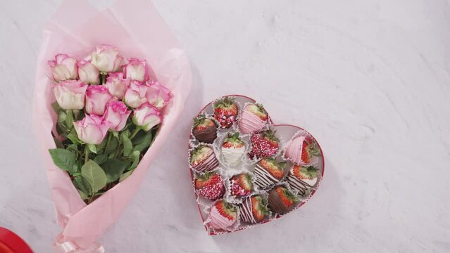 Flat lay. Step by step. Bouquet of pink roses with a box of chocolate dipped strawberries.