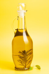 Jug with olive oil, on yellow background.