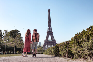 Couple standing at the Eiffel Tower in Paris, France.