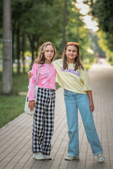 Portrait of young beautiful sisters in a summer park.