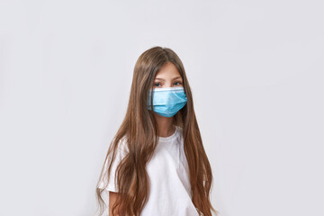 Little girl wearing medical mask looking at camera