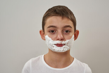 Portrait of little boy with shaving foam on face