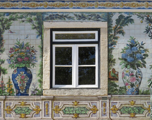 Streets of Lisbon. Traditional tiled facade with window and decoration with colorful flowers, plants and animals. Portugal. 