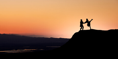 Silhouette of a dancing couple on a rock	