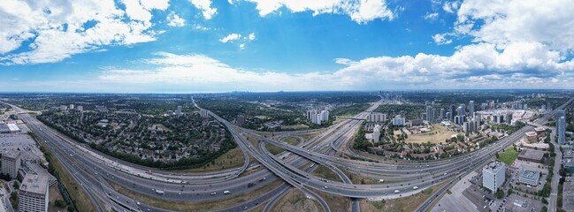 Top down aerial of cars drive across the expressway road in Canada. Cityscape and Highway. Transportation traffic at multilevel high speed road complex in North America.