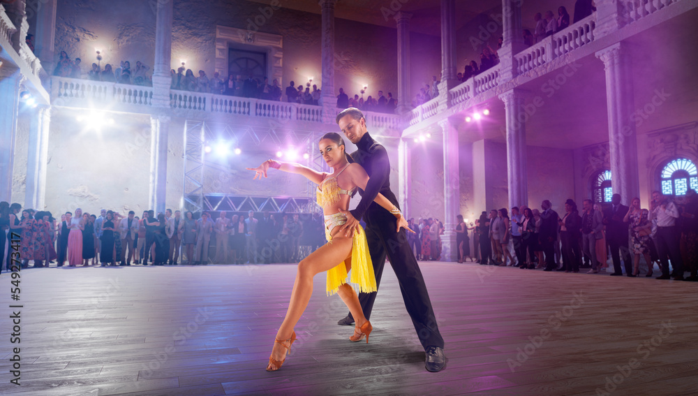 Wall mural couple dancers perform latin dance on large professional stage. ballroom dancing.