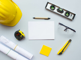top view design engineering and construction concept on grey background with tools, white paper, safety helmet, measurement. work space, civil engineering