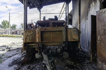 Fototapeta na wymiar burnt military armored car on the street of the ruined city