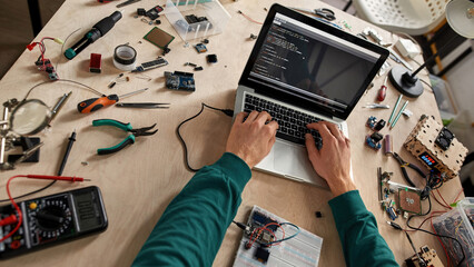 IT technician typing programming code of microchip