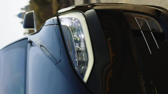 Vertical Video of Car Front Full Led Matrice Light of Tesla model X plaid. Adaptive car headlamp flashing light. Switched on led lights