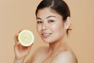 Portrait of young asian female with lemon