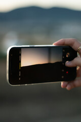 A woman taking a picture of a landscape